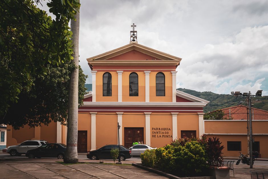 Facade of Parroquia Santiago de La Punta against a cloudy sky in Mérida, Venezuela, showcasing classic architecture.