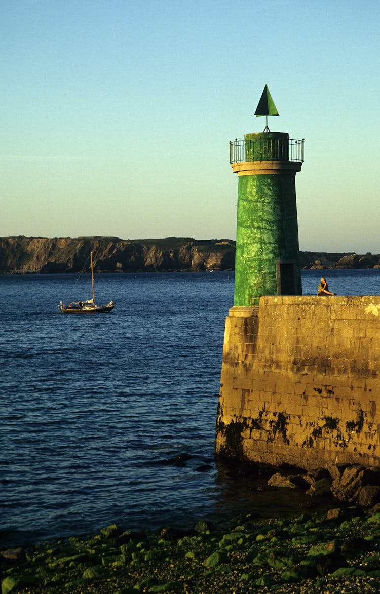 Green Lighthouse And Sailing Ship