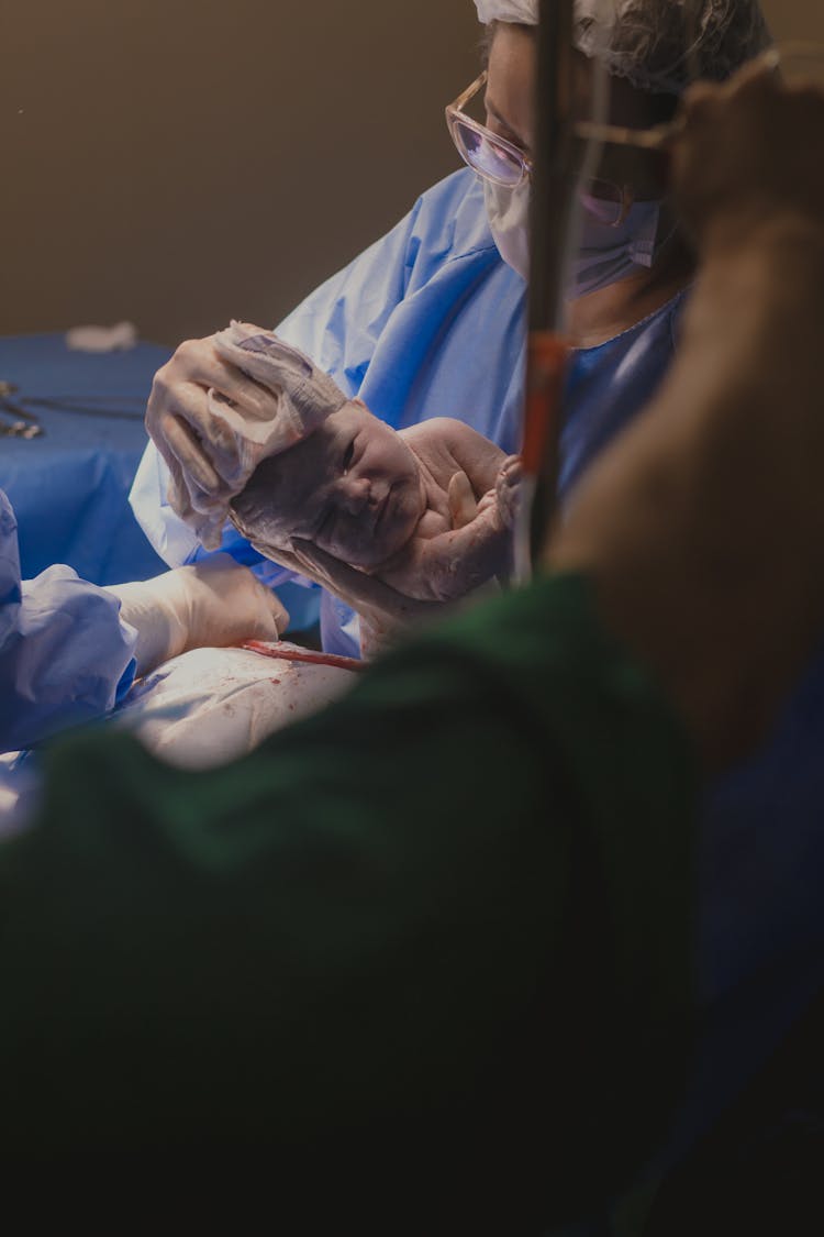 Surgeon Holding A Newborn Child 