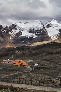 A serene mountain village beneath majestic snow-covered peaks, perfect for winter travel inspiration.