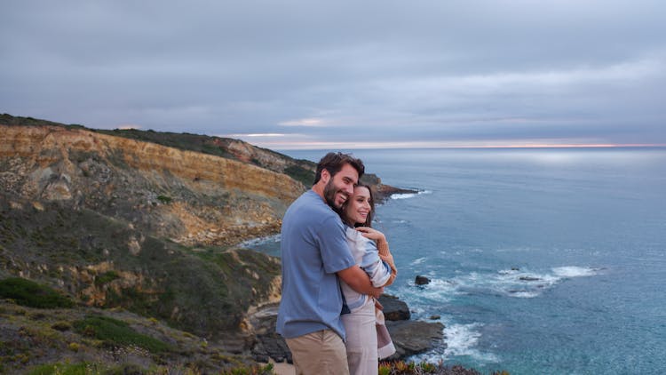 A Couple Embracing On Top Of The Mountain