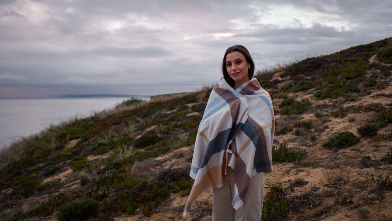 Free Woman in White and Blue Scarf Standing on Green Grass Field Stock Photo