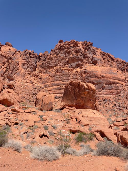 Free Stunning red rock cliff under a clear sky in a sunlit desert landscape. Stock Photo