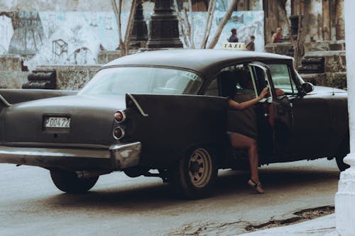 People Riding in a Vintage Balck Car