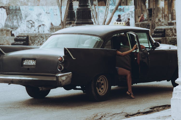 People Riding In A Vintage Balck Car