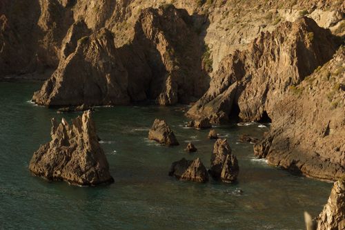 Free Stunning view of rugged coastal rock formations by the ocean at day. Stock Photo