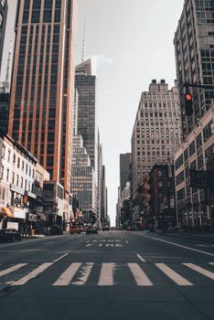 A street view of New York City showcasing towering skyscrapers under a clear sky.