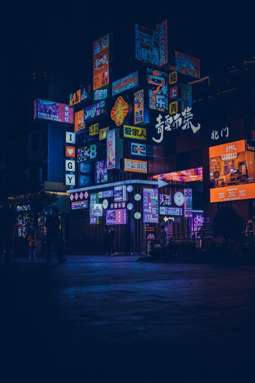 Free Captivating night scene of colorful neon signs illuminating a bustling city street. Stock Photo