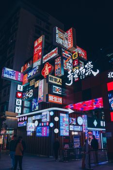 Vivid city street illuminated by colorful neon signs at night, capturing urban energy.