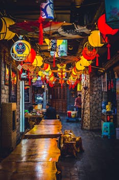 Colorful lanterns decorate a narrow street during a Chinese festival, creating a vibrant atmosphere.