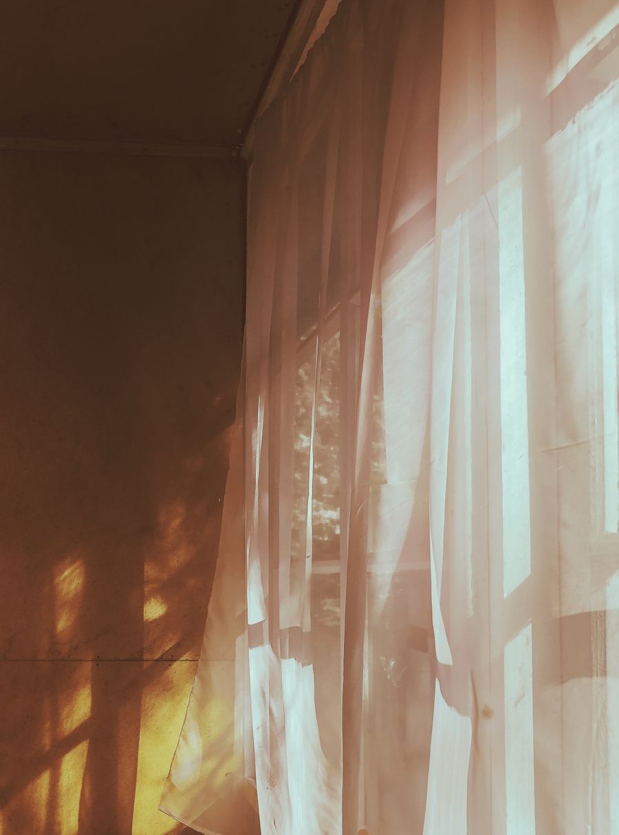 Warm morning sunlight falling through sheer curtains in a quiet room