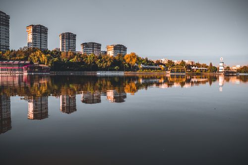 Free Stunning urban skyline reflecting on a calm lake with vibrant autumn foliage and tranquil atmosphere. Stock Photo