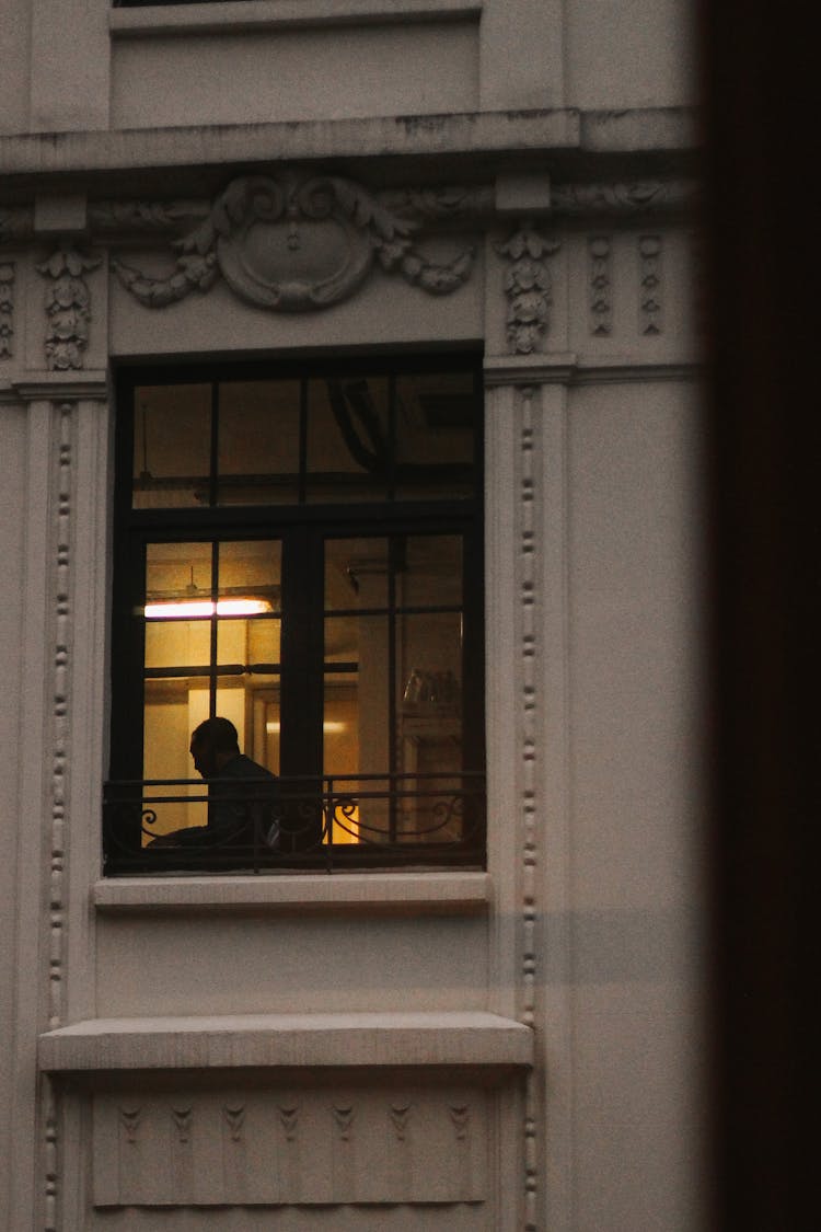 Silhouette Of Man In Window Of Old Building