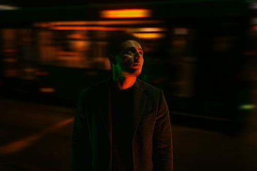 Free Captivating night portrait of a man looking upward with motion blur background, conveying mystery. Stock Photo
