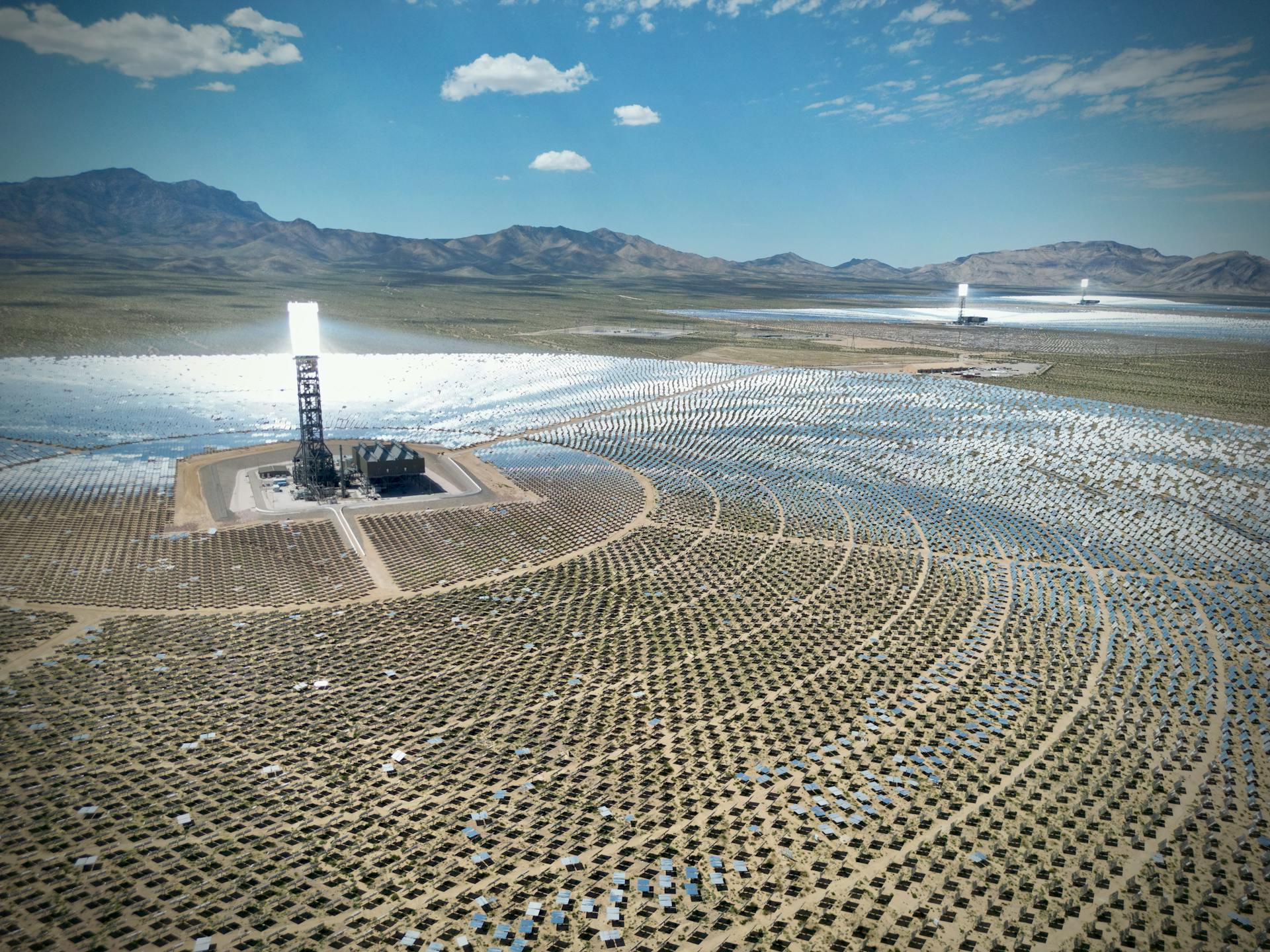 Stunning aerial view of the Ivanpah Solar Electric Generating System with mountainous backdrop.