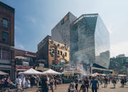 繁华的户外街头市场坐落于现代化的玻璃建筑之间，汇聚了城市中多元的人群