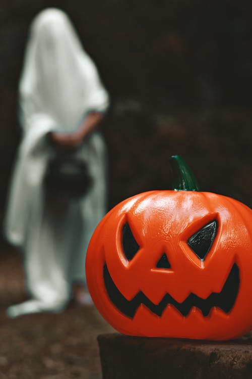 Jack O Lantern With  Person Representing a Ghost on Background