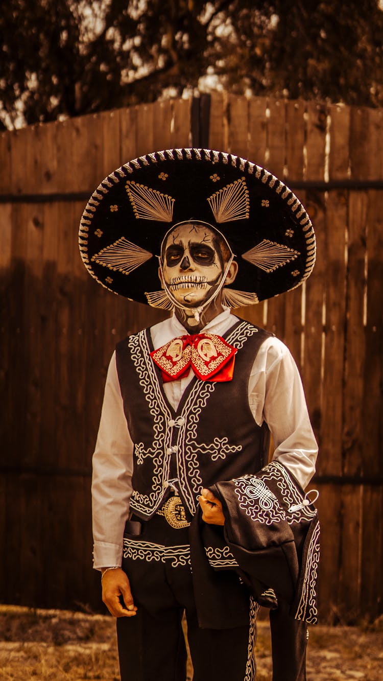 A Man In Costume With Skull Makeup Wearing Black And White Mariachi Hat