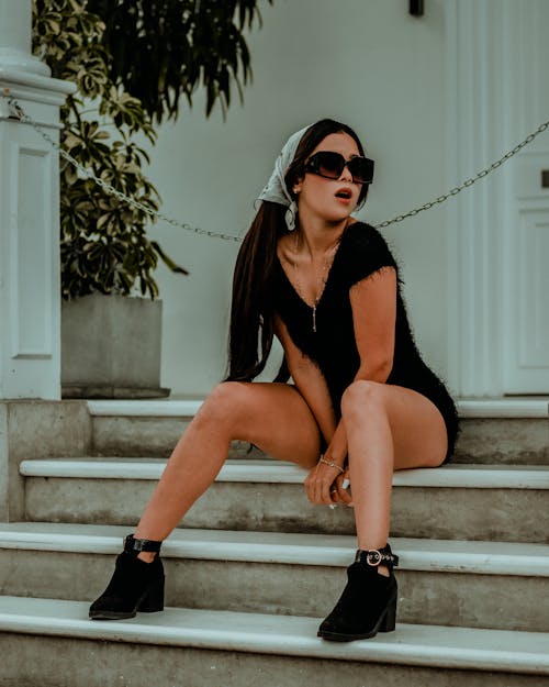 Brunette Woman in Sunglasses Sitting on Stairs