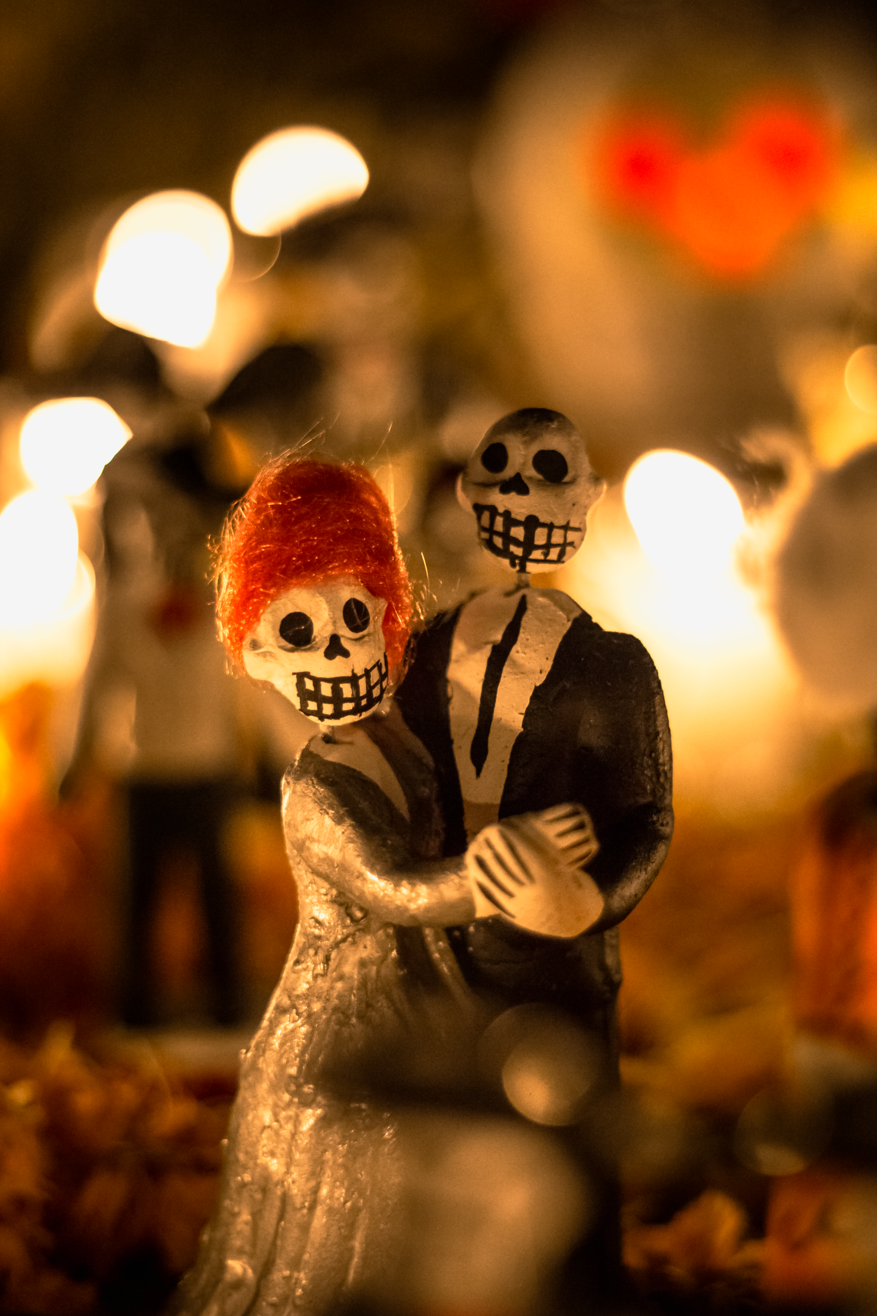 Close-up of colorful Day of the Dead figurines in Oaxaca, celebrating Mexican culture with warm lighting.