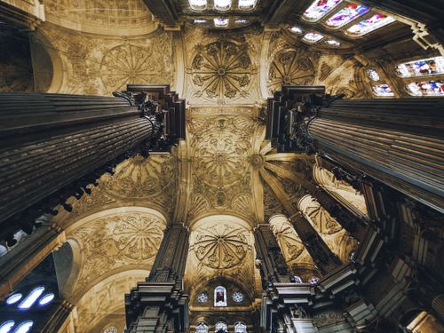 Free Stunning view of a Renaissance cathedral ceiling showcasing detailed columns and stained glass. Stock Photo