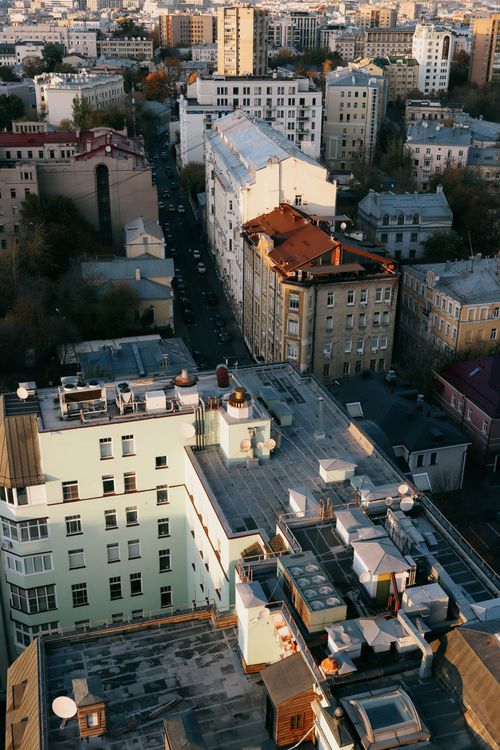 Free High-angle shot of city rooftops and streets at dusk with urban skyline. Stock Photo