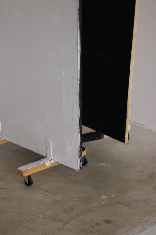 Free Simple mobile partition with rollers on a concrete floor, suitable for indoor spaces. Stock Photo