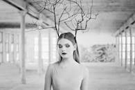 一幅描绘了树枝女人的创意黑白肖像，置于质朴的室内环境中