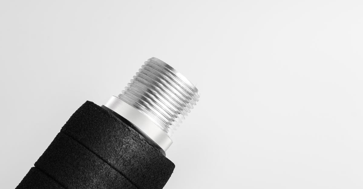 Detailed macro image of a metallic industrial connector on a white background.