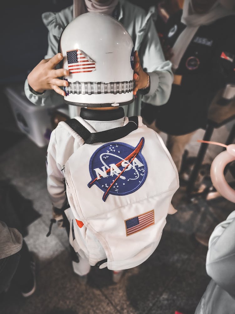 Kid Wearing A Helmet And Carrying A Backpack