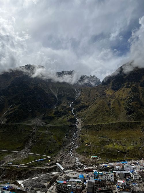 Free A breathtaking view of a mountain valley with a meandering stream under a cloudy sky. Stock Photo