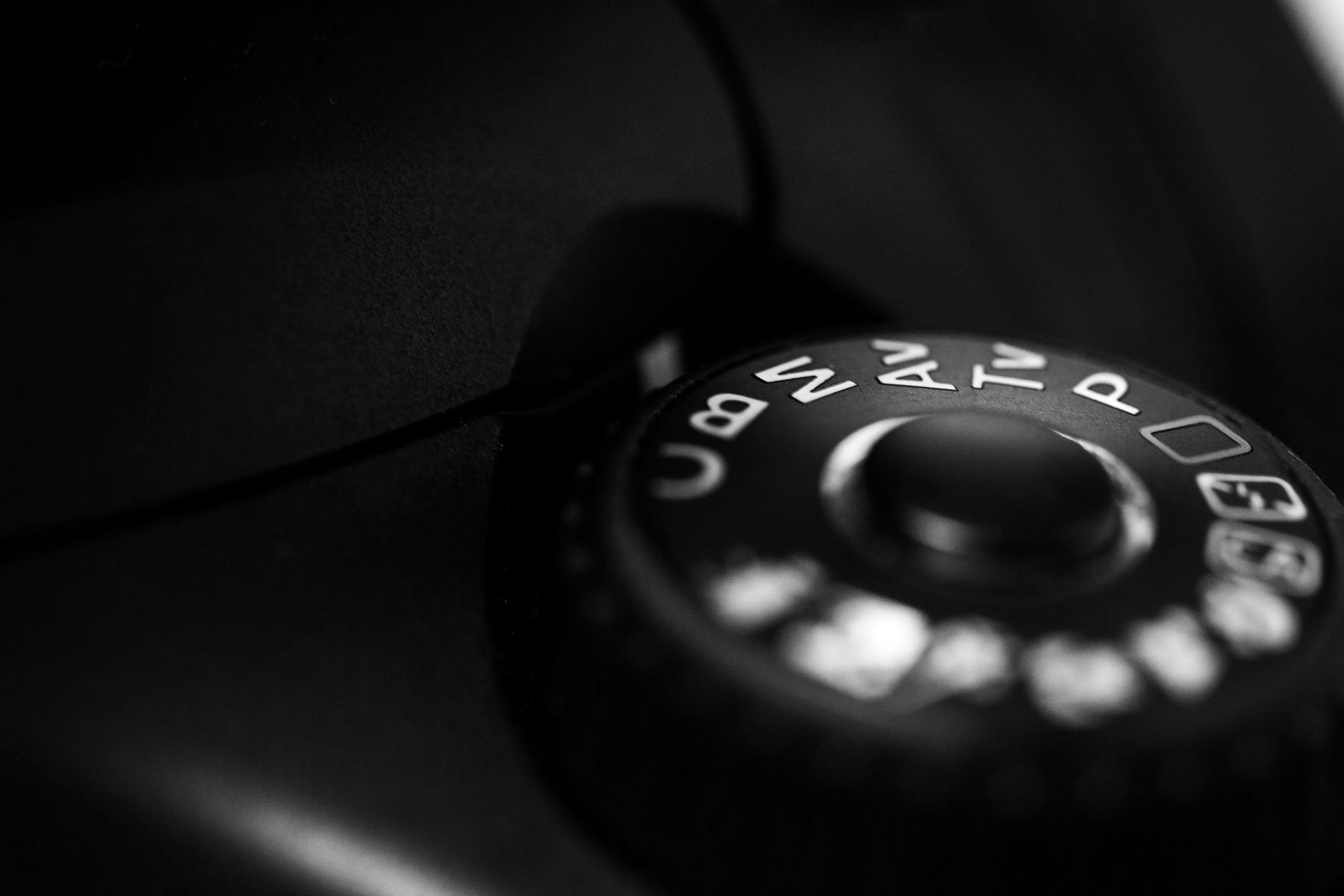 Detailed close-up of a camera mode dial highlighting settings in black and white contrast.