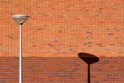 A Street Lamp Near a Brick Wall