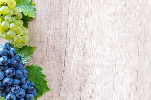 Grapes on Brown Wooden Surface