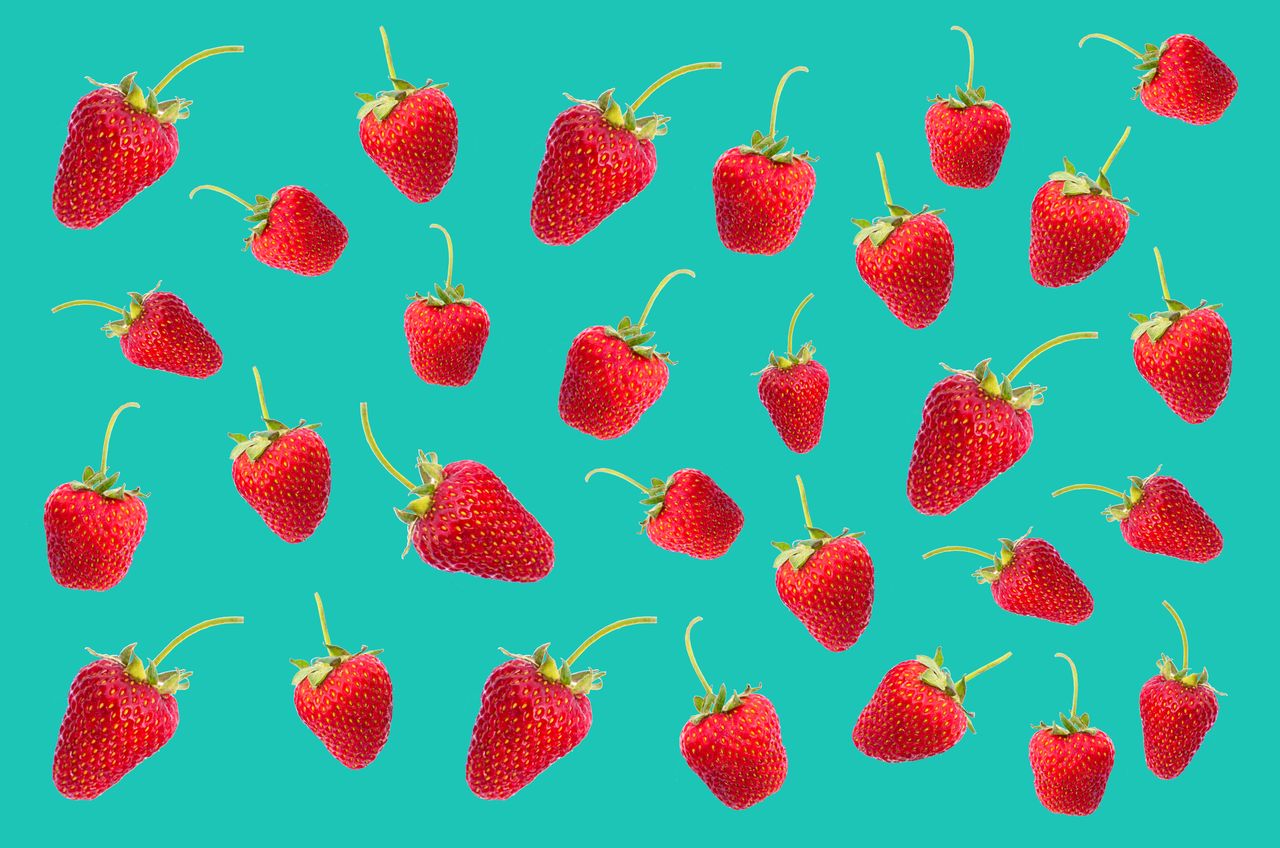 bright red strawberries arranged on a teal background showcasing fresh