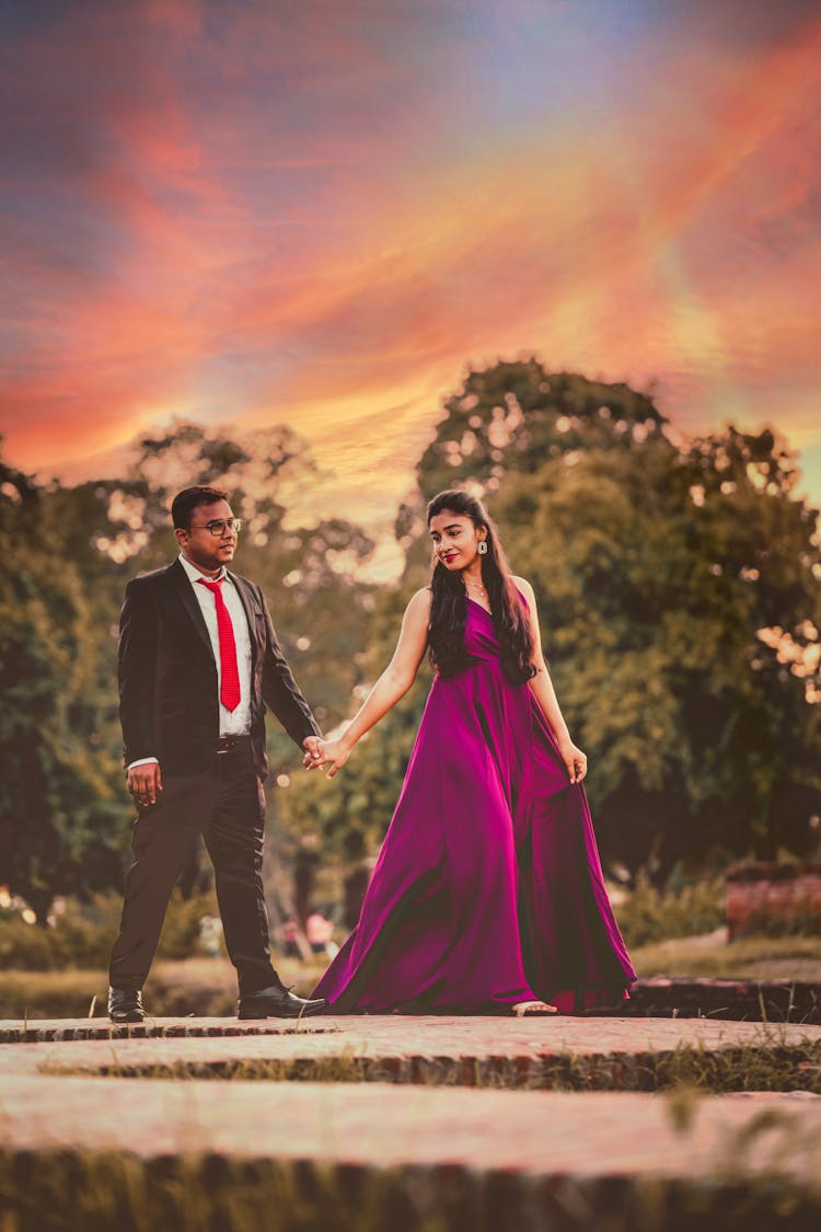 Photo Of A Man Walking With A Woman In A Purple Dress