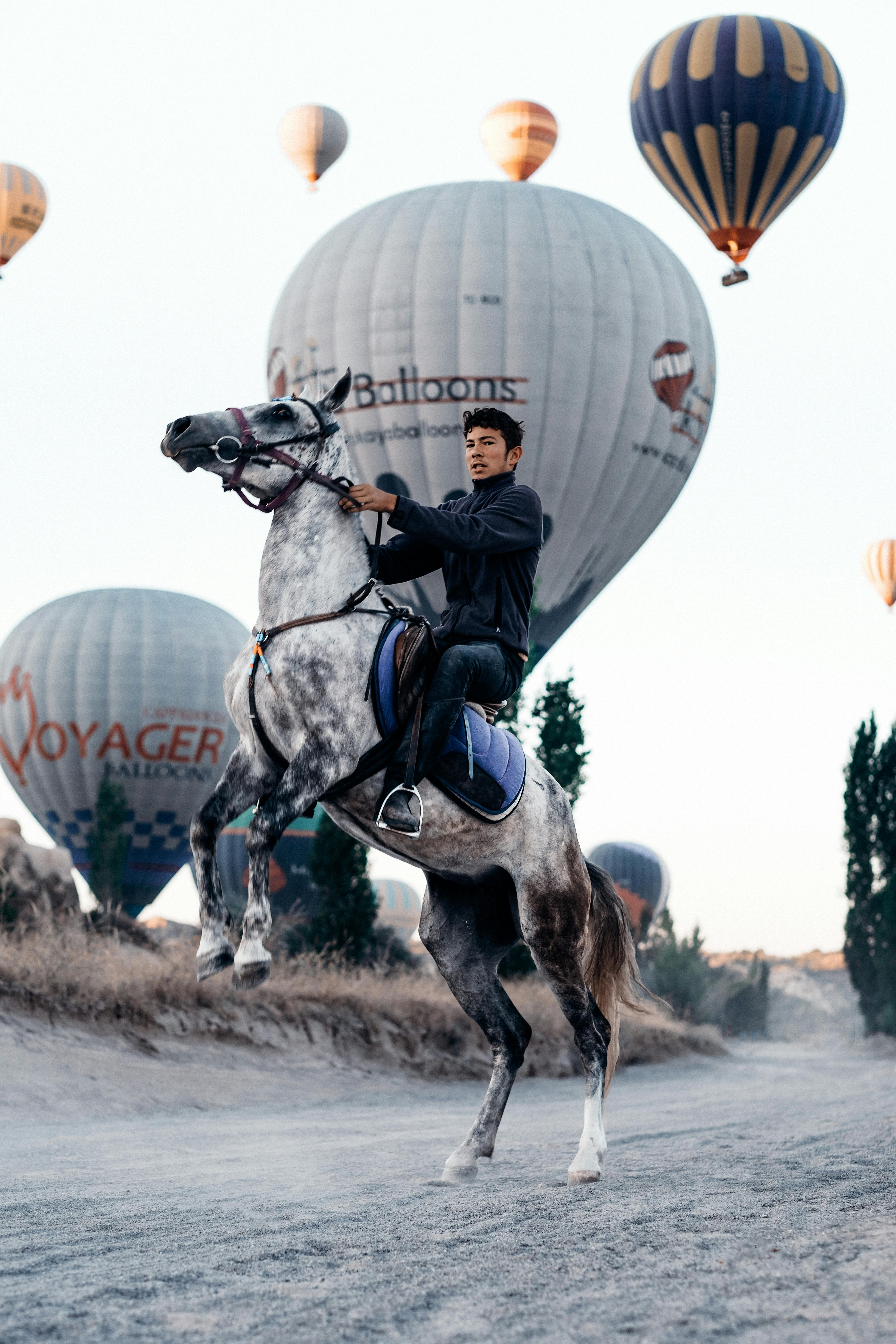 a man on a horseback and balloons in the background