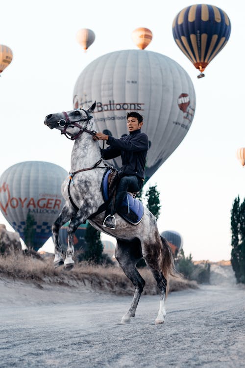 A Man on a Horseback and Balloons in the Background