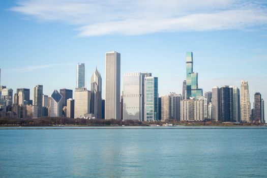 A breathtaking view of the Chicago skyline with iconic skyscrapers by the lake on a sunny day.