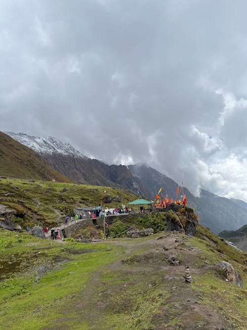 People Walking on Green Mountain Under White Clouds