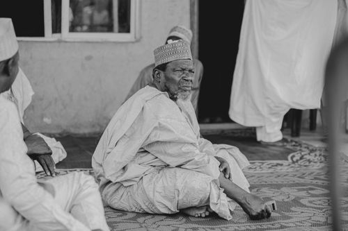 Free Black and white photo of a senior Muslim man sitting indoors in Keffi, Nigeria. Stock Photo