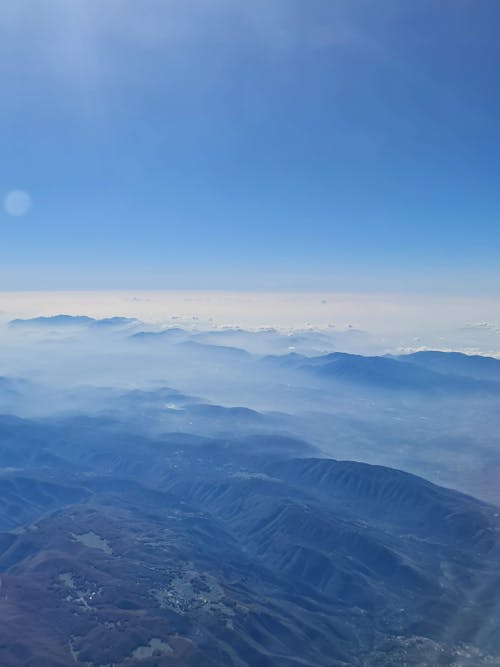 Free stock photo of airplane window, blue sky, mountains