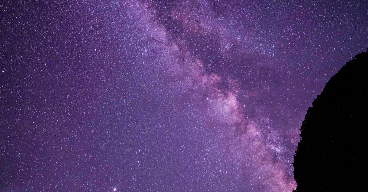 Stunning view of the Milky Way galaxy under a purple night sky, perfect for space enthusiasts.