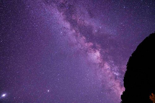 Free Stunning view of the Milky Way galaxy under a purple night sky, perfect for space enthusiasts. Stock Photo