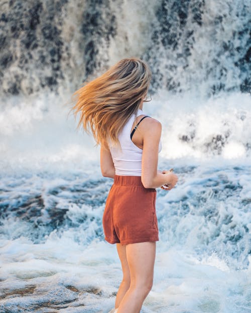 Back View of a Woman Near a Waterfall