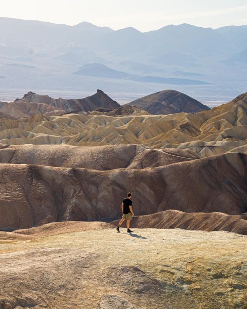 Free A lone hiker traverses the rugged terrain of Death Valley National Park. Stock Photo