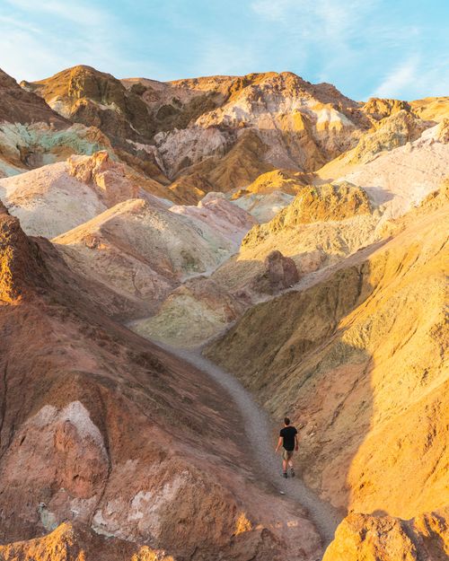 Free A lone hiker explores the vibrant and rugged terrain of Death Valley's scenic badlands. Stock Photo
