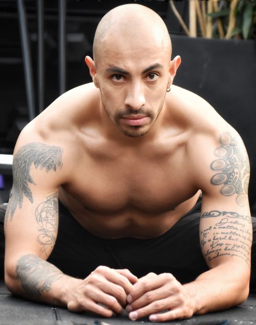 Free Bald muscular man with tattoos engaged in an intense fitness pose, showcasing strength and focus. Stock Photo
