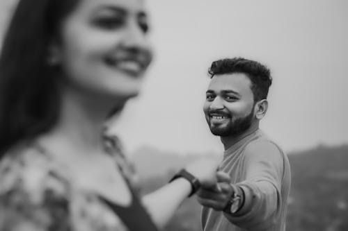 Grayscale Photo of Man and Woman Smiling