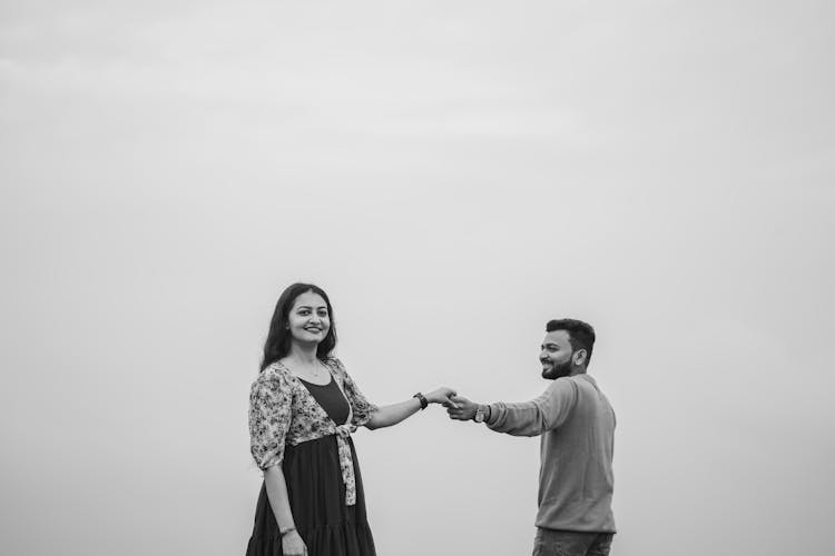 Happy Couple Standing And Holding Hands